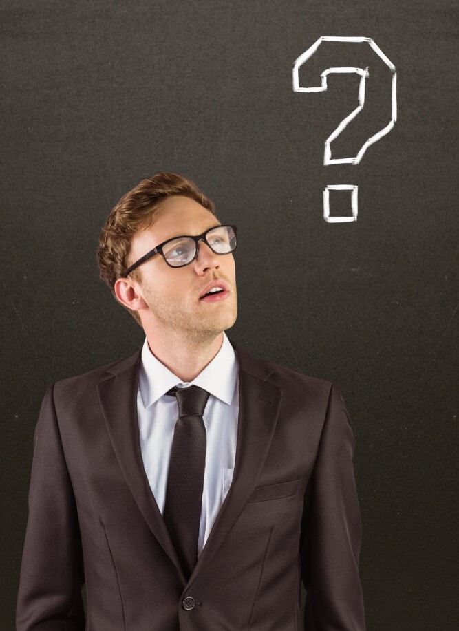 Intellectual man at Acceleratron, wearing glasses, looks at a question mark, symbolizing curiosity in coding and programming in Pune & Kolkata.